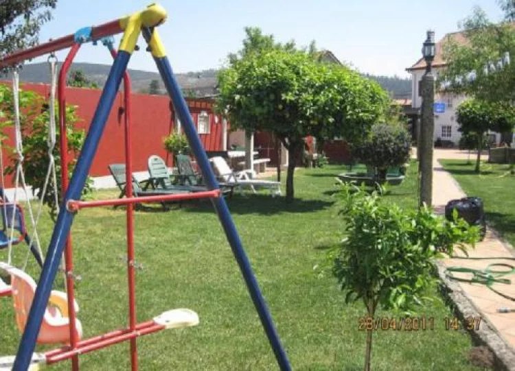 Jardín con césped, árboles frutales y columpio