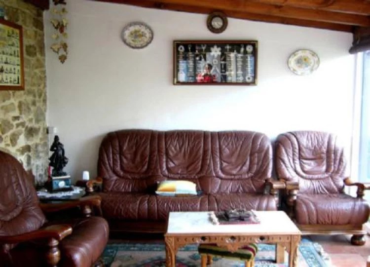 Salón con sofás de cuero y paredes de piedra